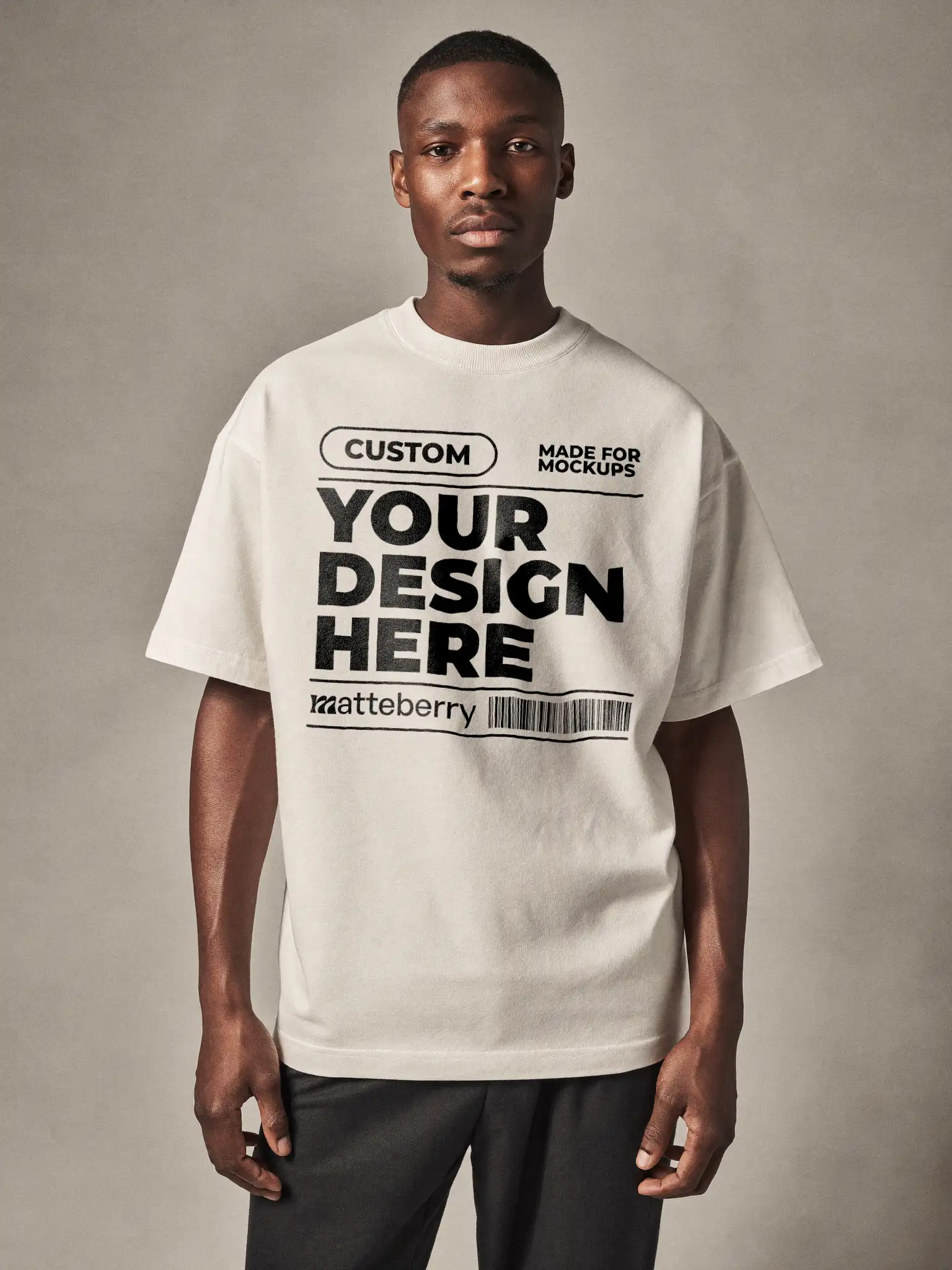 Man in a white oversized tee against a plain gray background